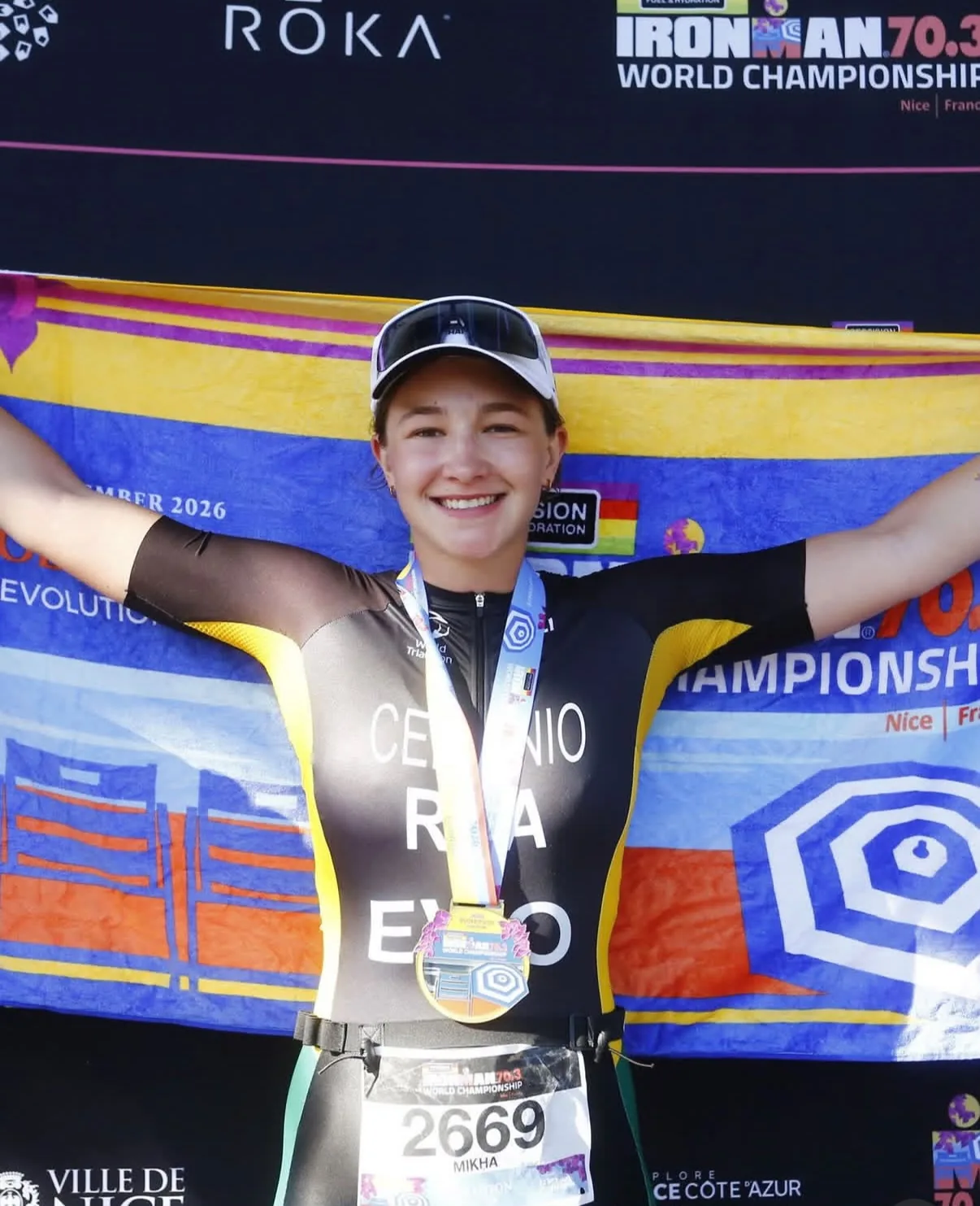 Mikha Ceronio celebrating with her finisher medal and event flag at the IRONMAN 70.3 World Championship in Nice