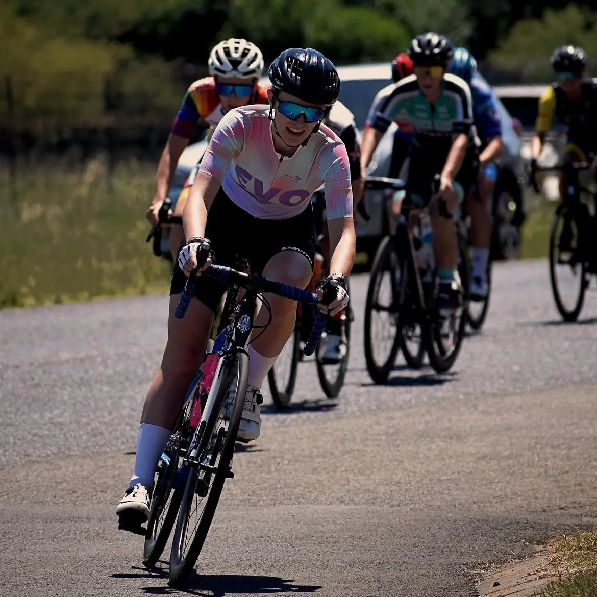 Rider in EVO kit leading a bunch through a corner in a road race
