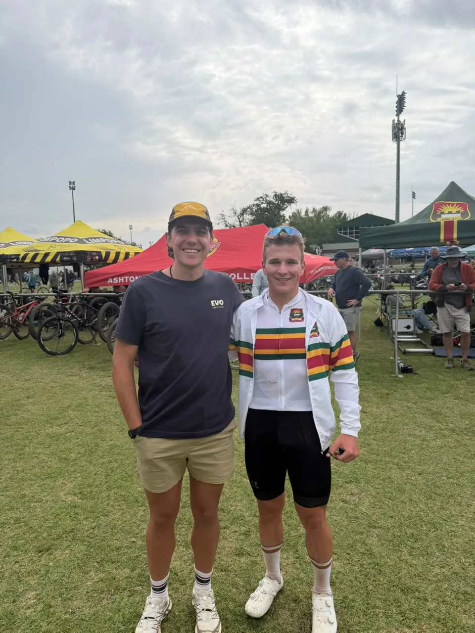 James Allan standing with a young rider in South African champion kit at a race venue