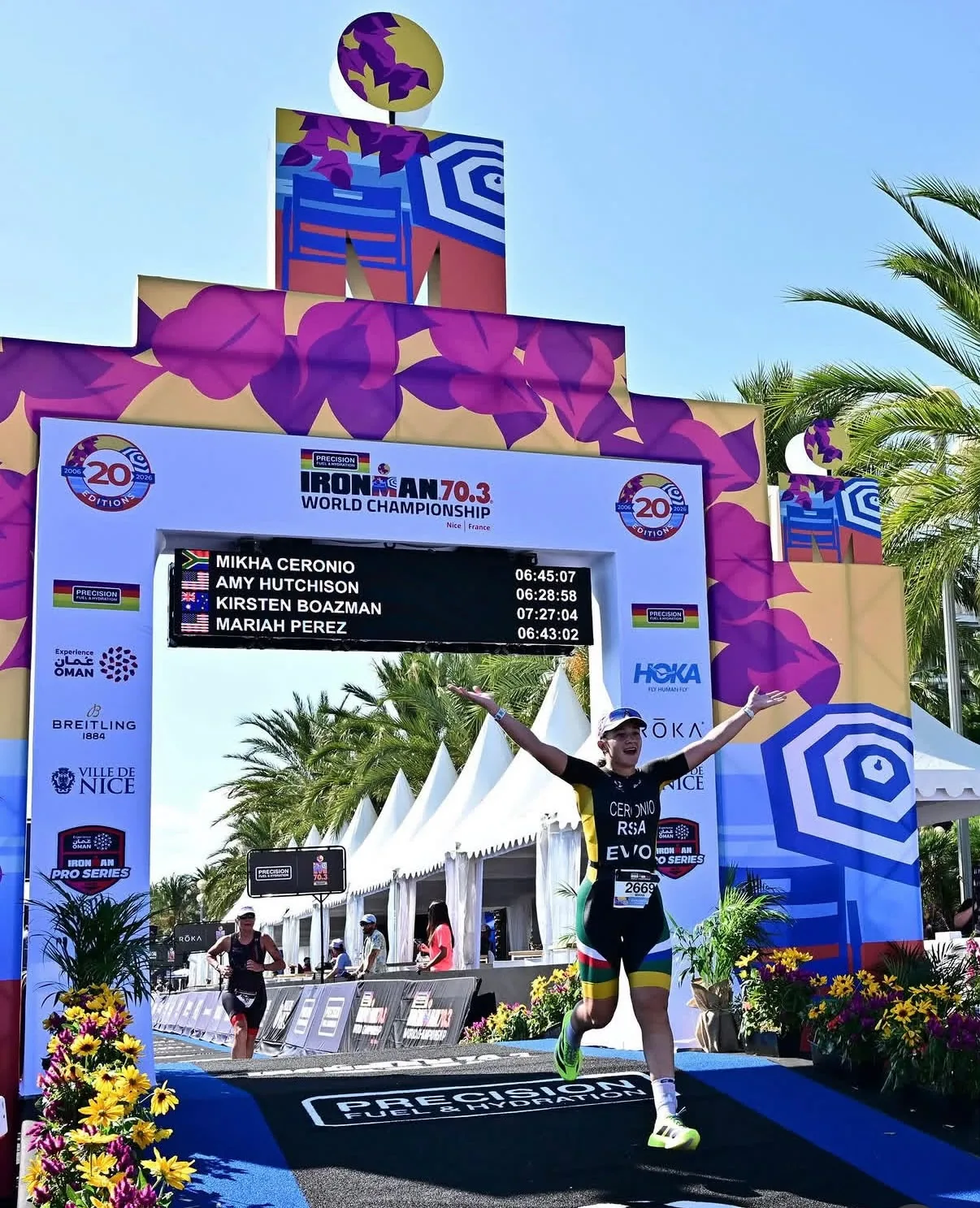 Mikha Ceronio raising her arms under the IRONMAN 70.3 World Championship finish arch in Nice